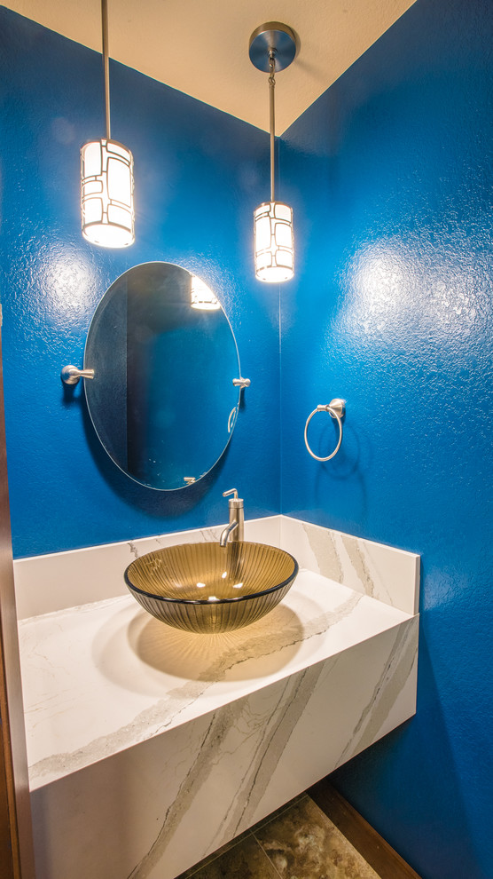 This is an example of a mid-sized transitional powder room in Seattle with blue walls, laminate floors, a vessel sink, engineered quartz benchtops and white benchtops.