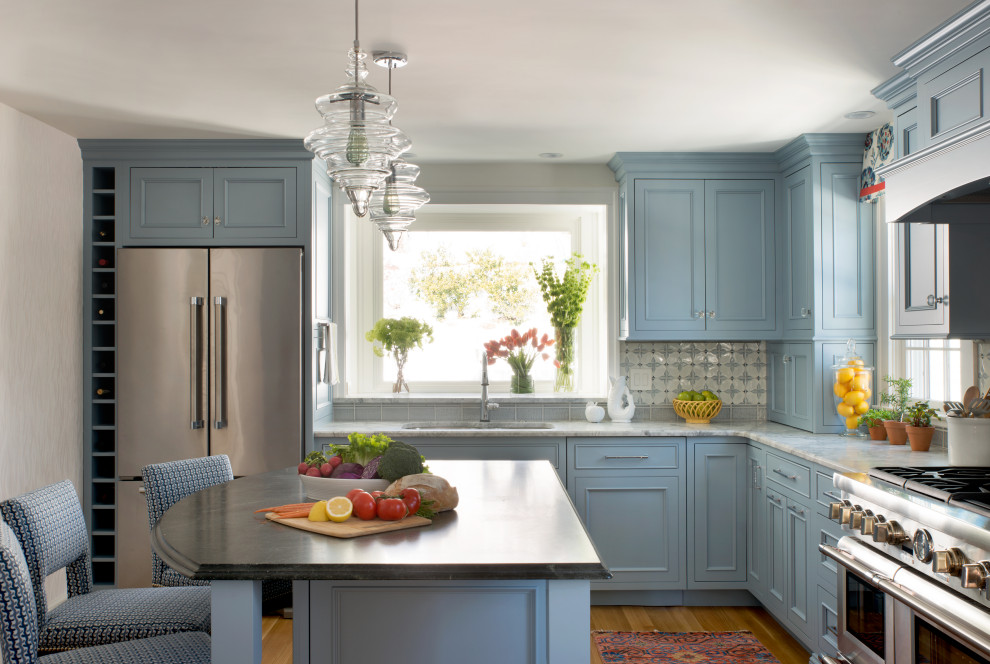 This is an example of a mid-sized traditional l-shaped kitchen in Boston with an undermount sink, beaded inset cabinets, blue cabinets, quartz benchtops, blue splashback, ceramic splashback, stainless steel appliances, with island, brown floor, grey benchtop and medium hardwood floors.