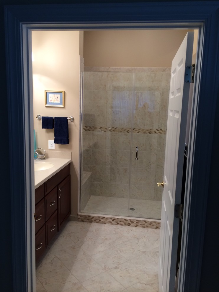 Design ideas for a mid-sized transitional 3/4 bathroom in DC Metro with dark wood cabinets, an alcove shower, beige tile, beige walls, porcelain floors, an undermount sink, engineered quartz benchtops, beige floor, a hinged shower door and beige benchtops.