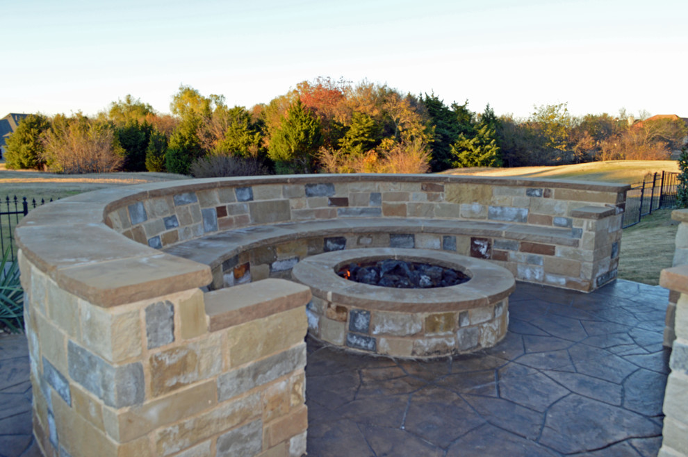 Large mediterranean backyard patio in Dallas with a fire feature, natural stone pavers and no cover.