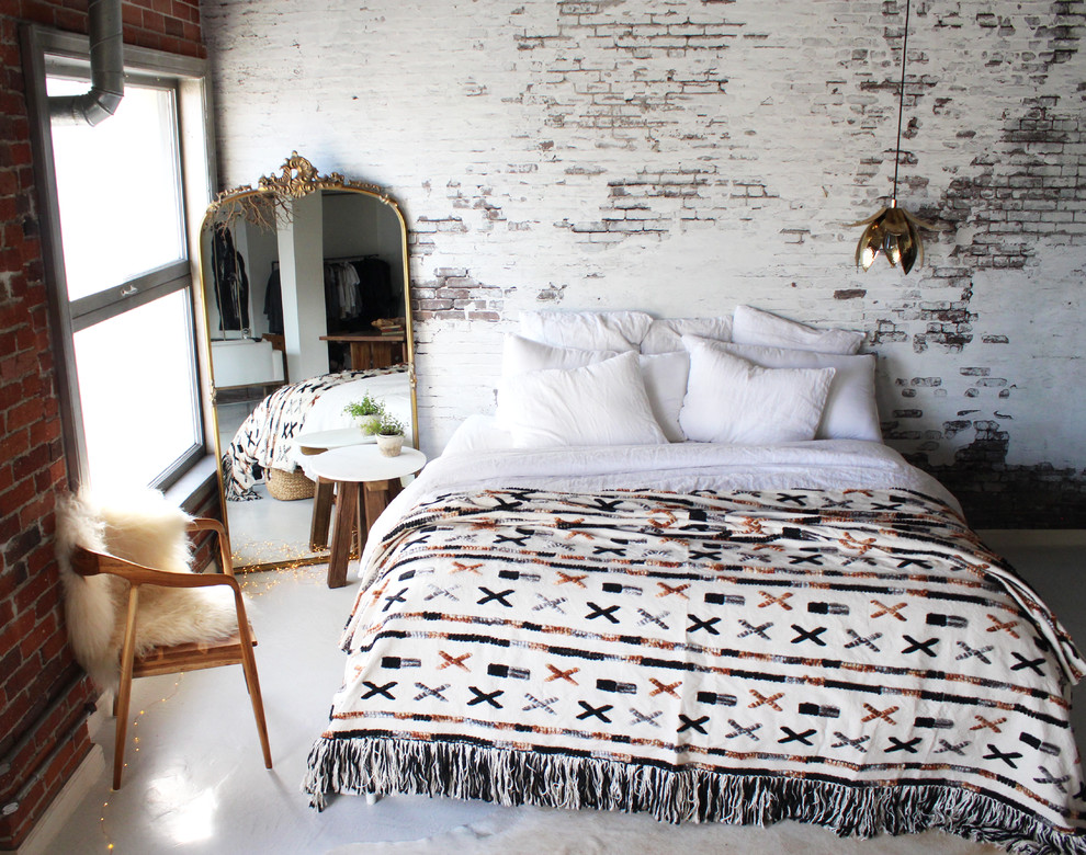 Inspiration for an industrial loft-style bedroom in Los Angeles with white walls, concrete floors and white floor.