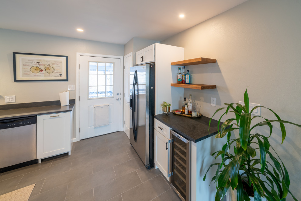 Exempel på ett mellanstort modernt grå grått kök, med en undermonterad diskho, skåp i shakerstil, vita skåp, bänkskiva i kvarts, vitt stänkskydd, stänkskydd i tunnelbanekakel, rostfria vitvaror, klinkergolv i porslin och grått golv