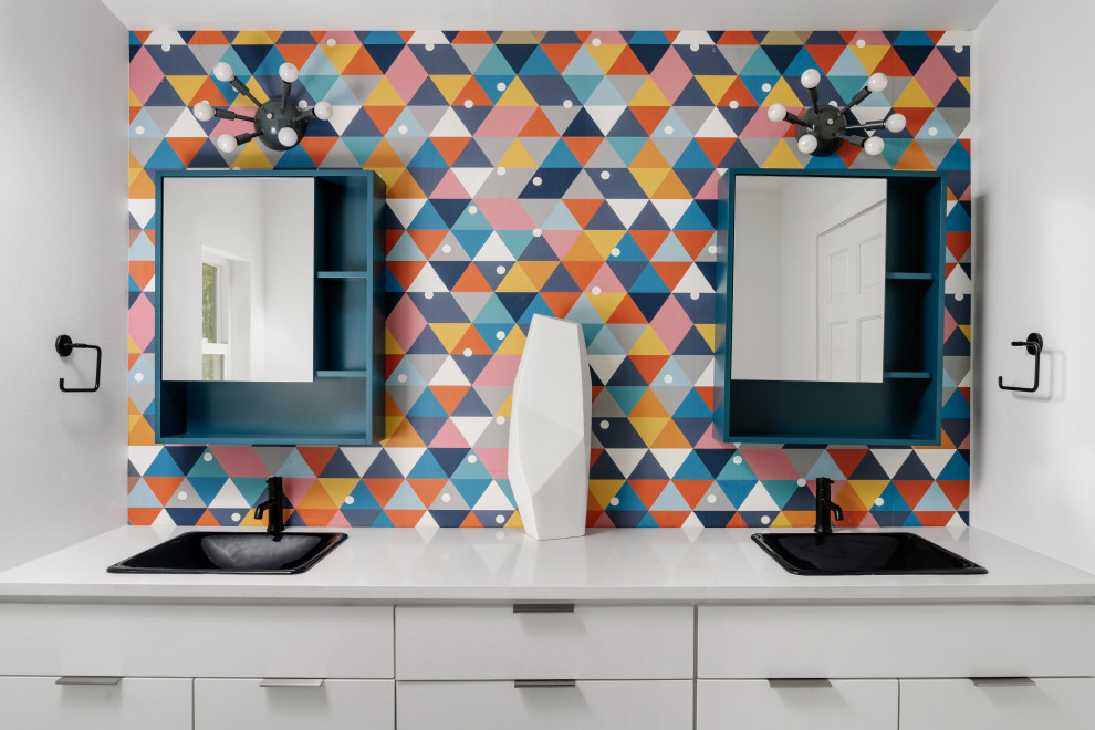 This is an example of a mid-sized scandinavian kids bathroom in Austin with flat-panel cabinets, white cabinets, a drop-in tub, blue tile, porcelain tile, blue walls, porcelain floors, a drop-in sink, engineered quartz benchtops, grey floor, grey benchtops, a double vanity, a floating vanity and wallpaper.