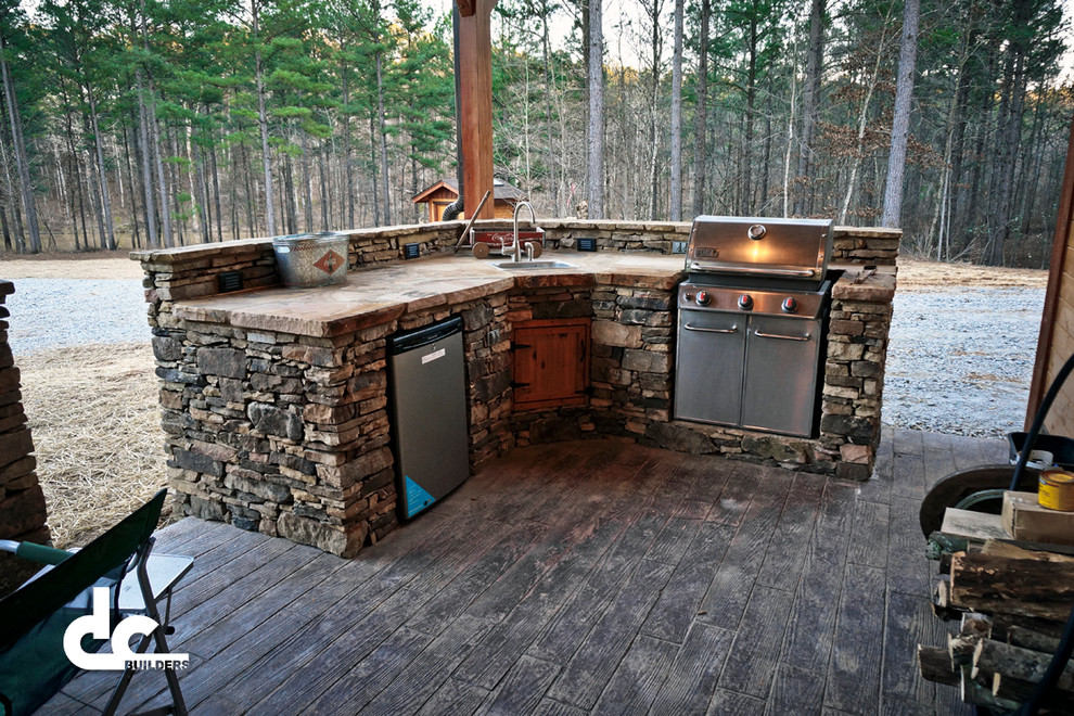 Large country courtyard patio in Atlanta with an outdoor kitchen, stamped concrete and a roof extension.