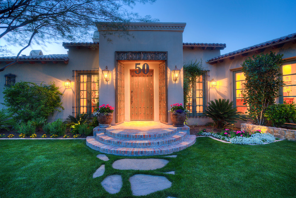 Design ideas for a mid-sized mediterranean front yard partial sun garden in Phoenix with natural stone pavers.