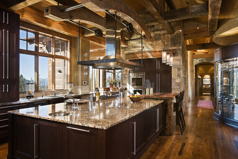 Example of a large mountain style dark wood floor and brown floor eat-in kitchen design with a drop-in sink, brown cabinets, colored appliances and an island