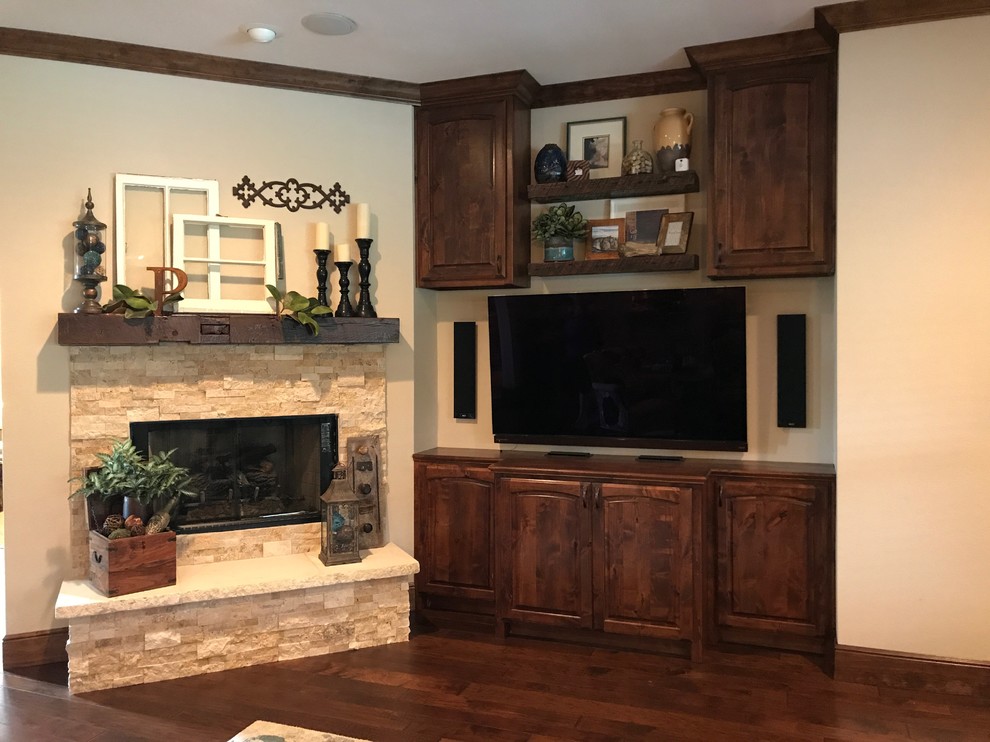 This is an example of a mid-sized transitional open concept family room in Dallas with beige walls, dark hardwood floors, a stone fireplace surround, a wall-mounted tv, brown floor and a standard fireplace.
