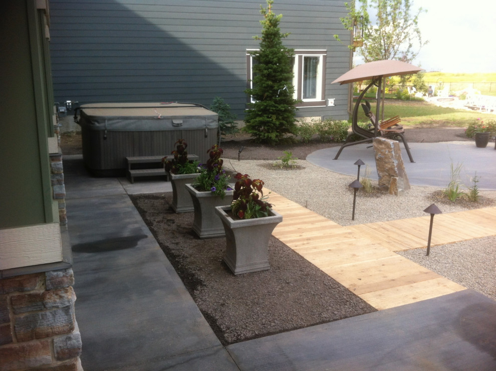 This is an example of a large contemporary backyard garden in Calgary with a water feature and gravel.