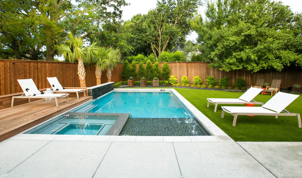Exemple d'une piscine arrière tendance rectangle avec un bain bouillonnant.
