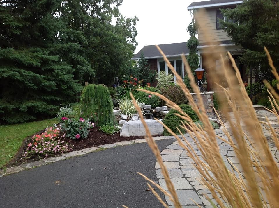 This is an example of a large transitional front yard gravel formal garden in Ottawa.