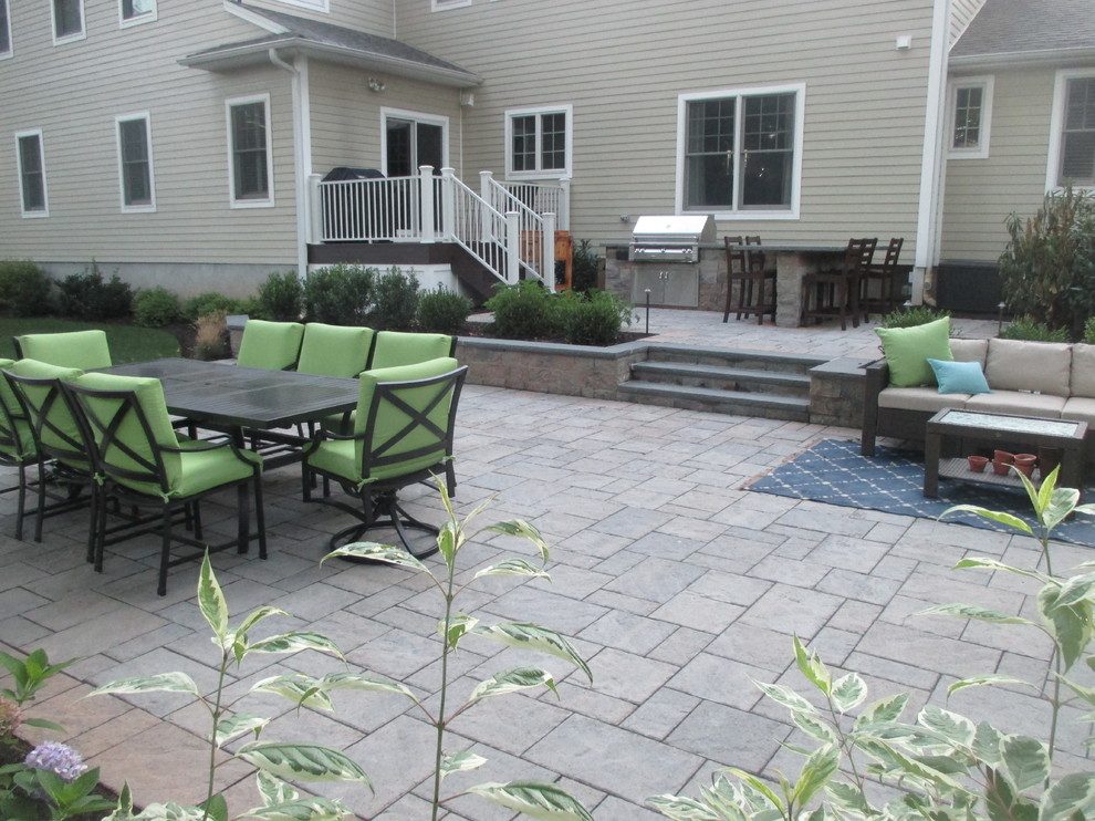 Inspiration for a large traditional backyard patio in New York with a fire feature, natural stone pavers and no cover.