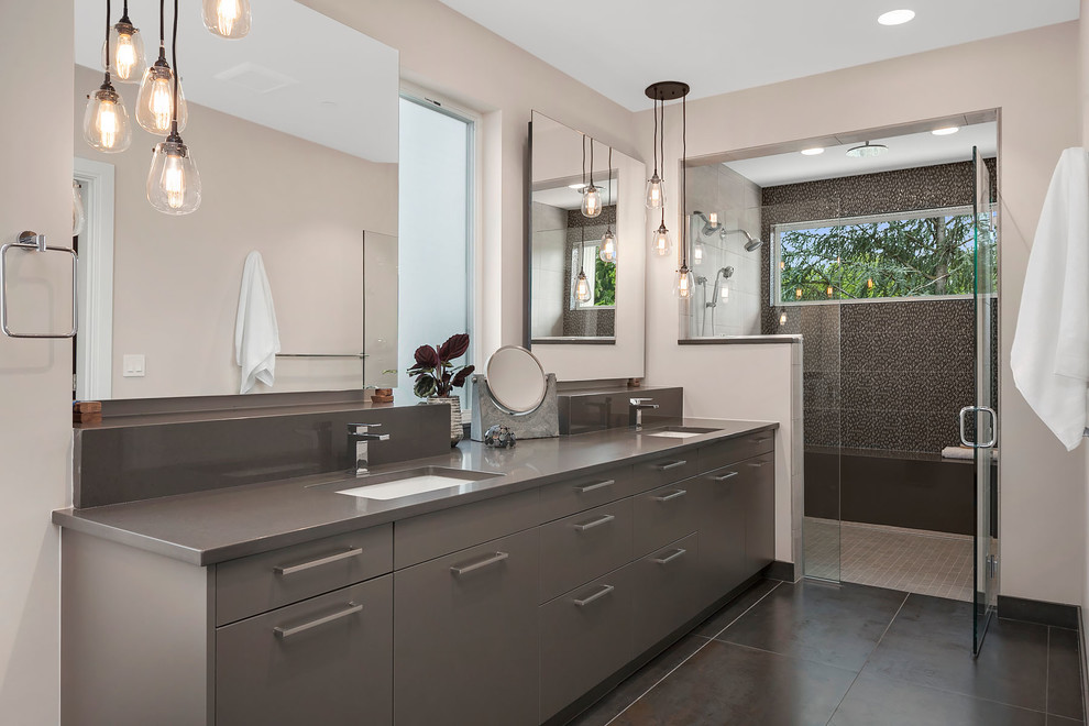 This is an example of a contemporary master bathroom in Seattle with flat-panel cabinets, grey cabinets, an alcove shower, gray tile, beige walls, an undermount sink, brown floor and a hinged shower door.