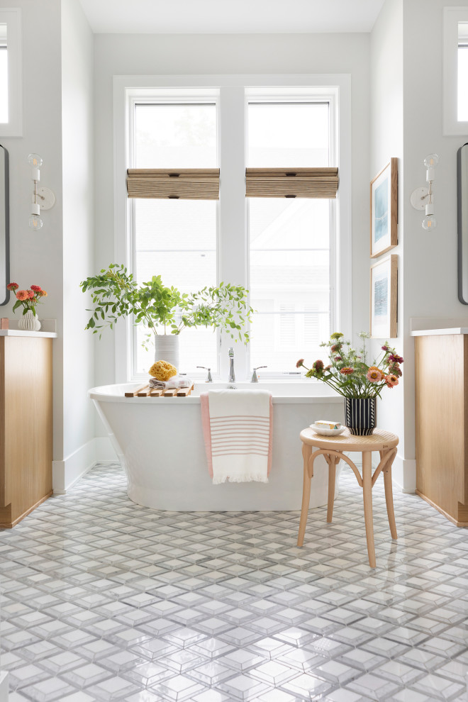 Стильный дизайн: большая главная ванная комната в морском стиле с светлыми деревянными фасадами, отдельно стоящей ванной, серыми стенами, полом из керамической плитки, столешницей из искусственного кварца, серым полом, нишей и встроенной тумбой - последний тренд