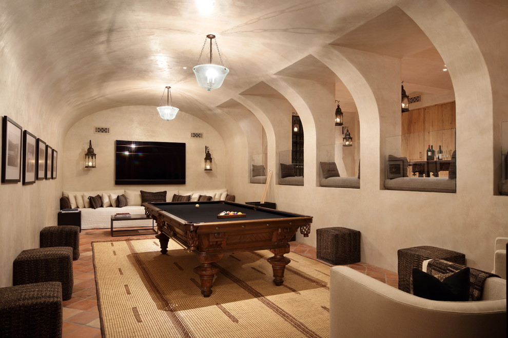 This is an example of a mediterranean basement in Los Angeles with beige walls, terra-cotta floors and orange floor.
