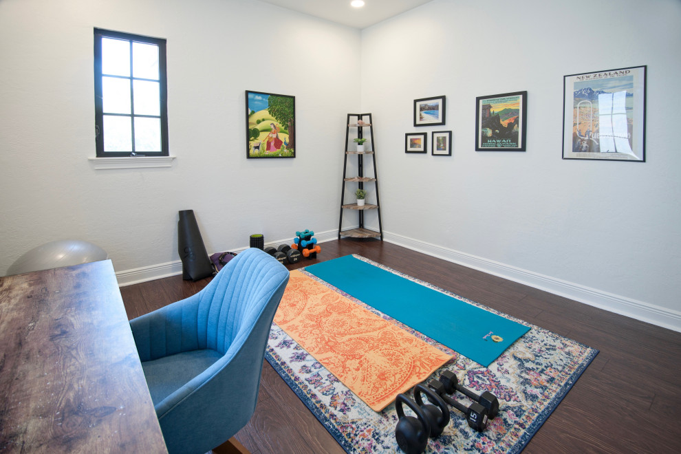 This is an example of a small coastal home yoga studio in Miami with white walls, laminate floors and brown floors.