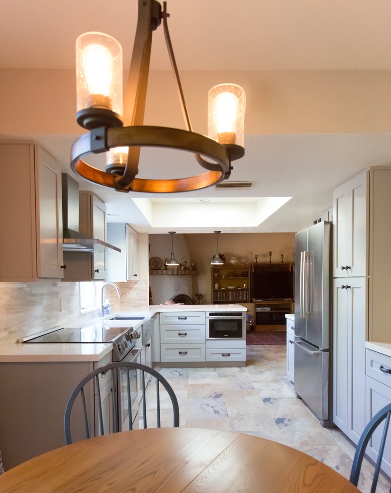 Mid-sized transitional u-shaped porcelain tile kitchen photo in Phoenix with a farmhouse sink, shaker cabinets, gray cabinets, quartz countertops, gray backsplash, porcelain backsplash, stainless steel appliances and a peninsula