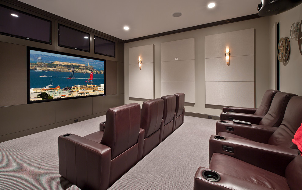 This is an example of a transitional home theatre in Seattle with a projector screen and grey floor.