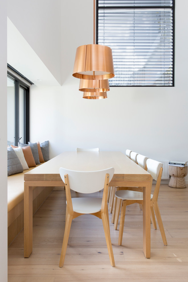 Contemporary dining room in Melbourne with white walls, light hardwood floors and beige floor.