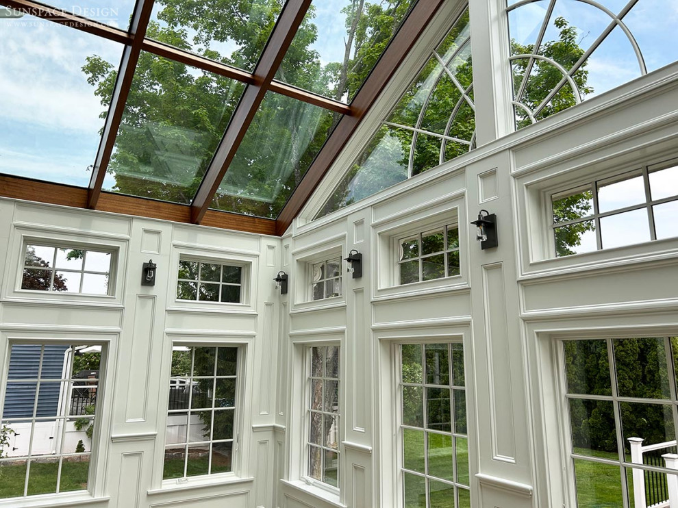 Exemple d'une véranda victorienne de taille moyenne avec sol en stratifié, aucune cheminée, un plafond en verre et un sol marron.