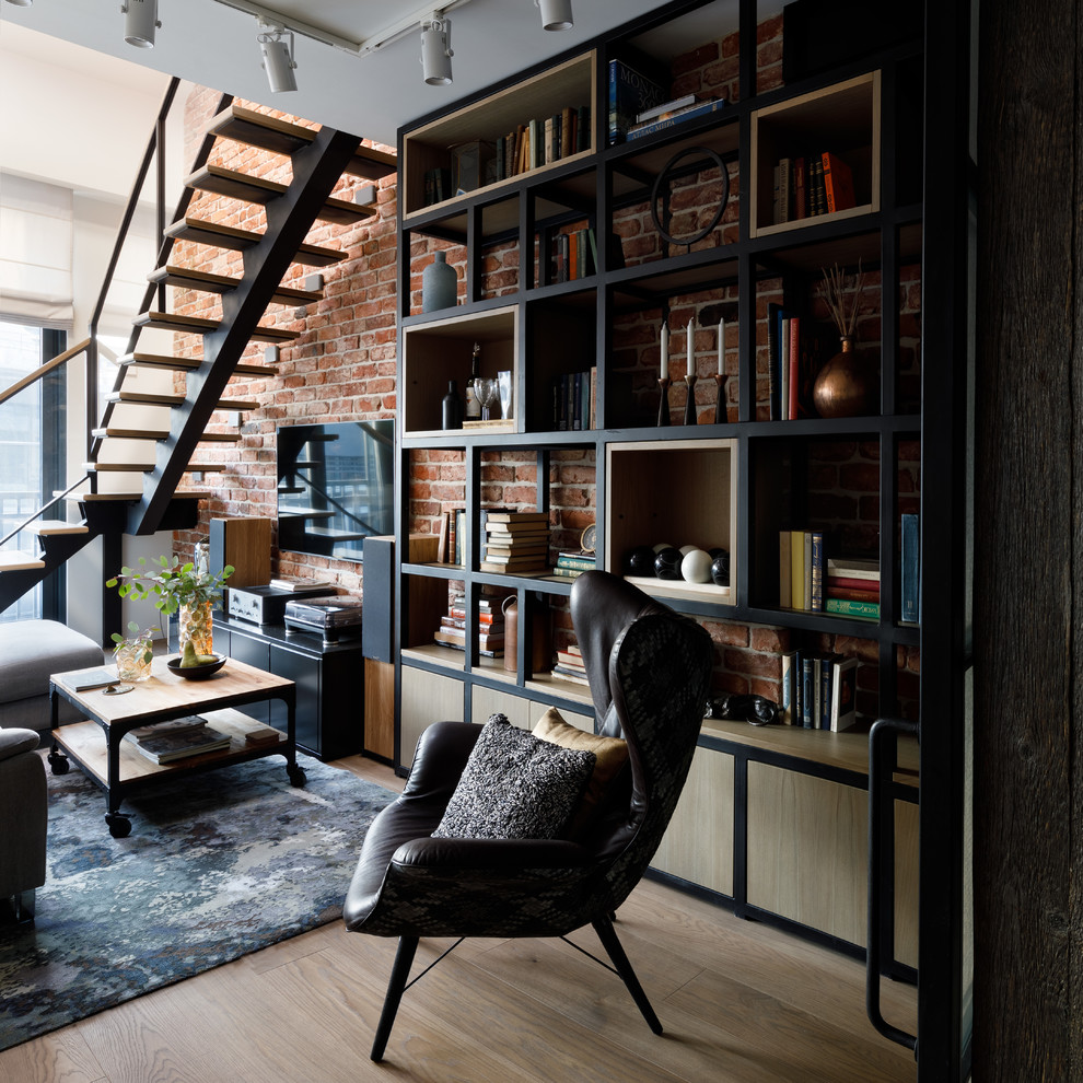 Inspiration for a mid-sized industrial loft-style living room in Moscow with a wall-mounted tv, a library, red walls, medium hardwood floors, no fireplace and beige floor.