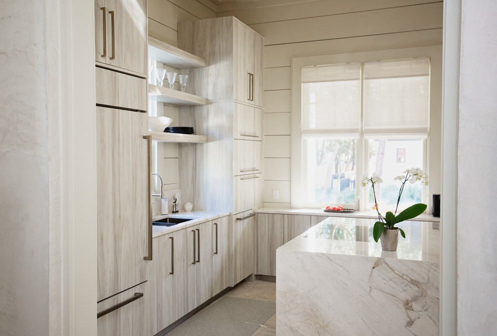 Example of a large trendy l-shaped limestone floor, beige floor and exposed beam eat-in kitchen design in Miami with a drop-in sink, flat-panel cabinets, white cabinets, quartzite countertops, white backsplash, granite backsplash, paneled appliances, an island and white countertops