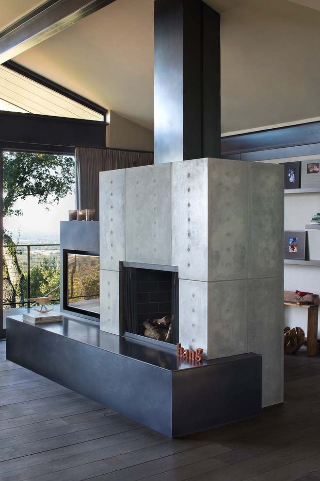 Photo of a mid-sized modern master bedroom in San Francisco with beige walls, dark hardwood floors, a standard fireplace and a concrete fireplace surround.