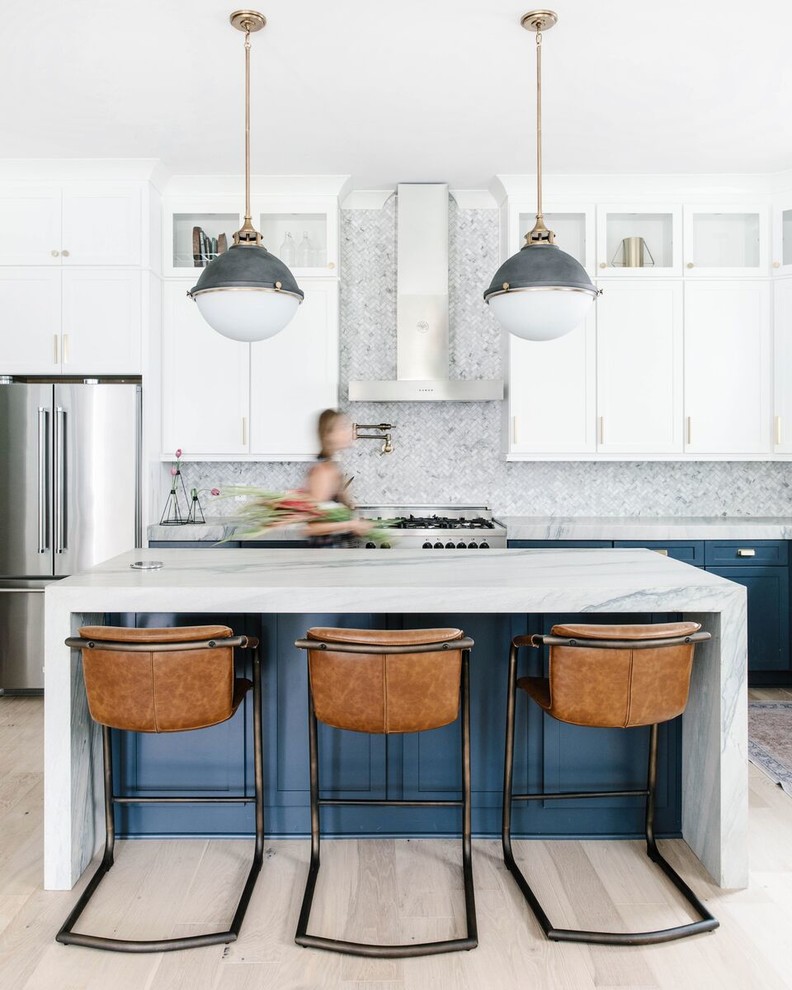 Inspiration for a transitional l-shaped kitchen in Charlotte with shaker cabinets, blue cabinets, grey splashback, stainless steel appliances, light hardwood floors, with island, grey benchtop and beige floor.