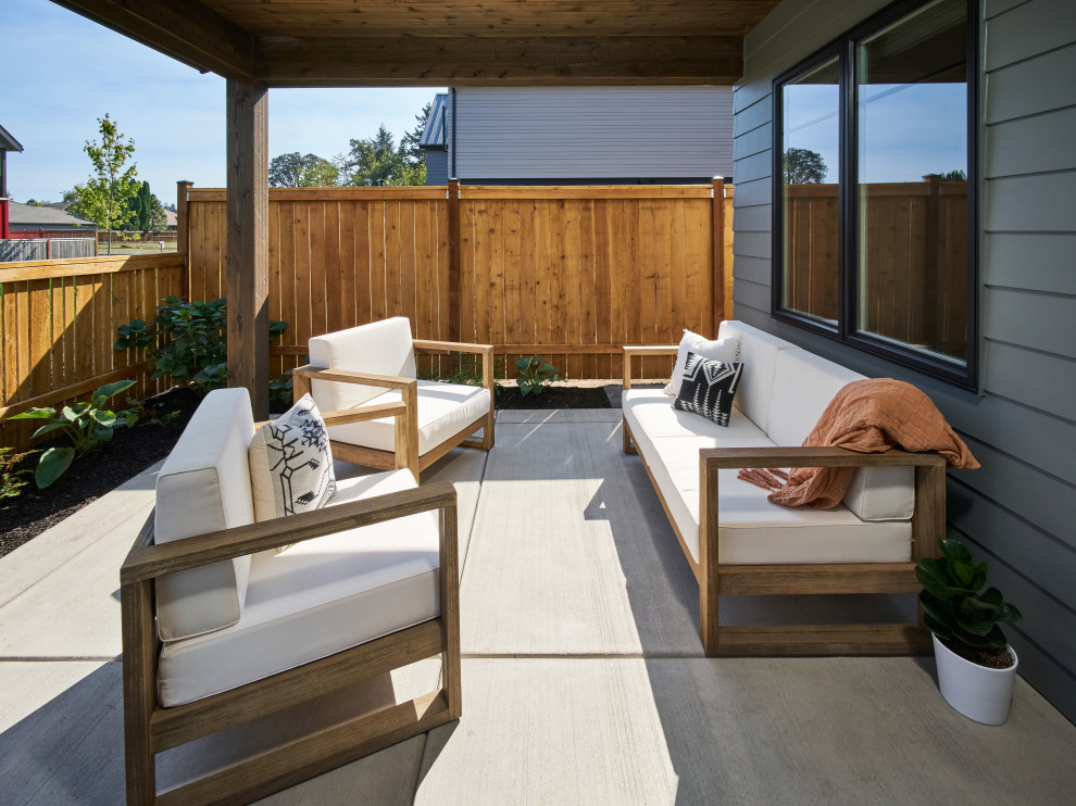 Cette photo montre une petite terrasse arrière et au rez-de-chaussée nature avec des solutions pour vis-à-vis et une extension de toiture.