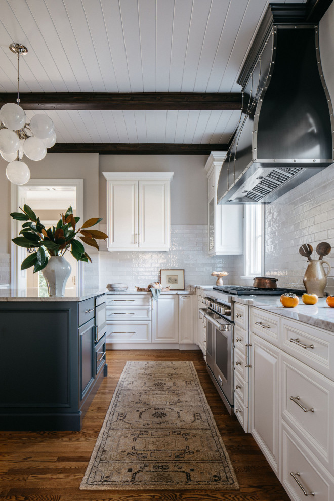 Example of a mid-sized medium tone wood floor, brown floor and exposed beam eat-in kitchen design in Chicago with recessed-panel cabinets, white cabinets, quartzite countertops, white backsplash, subway tile backsplash, stainless steel appliances, an island and white countertops