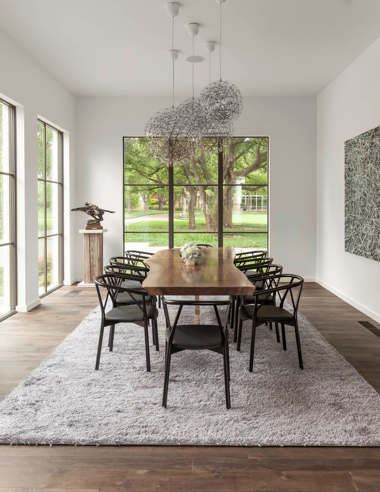 Contemporary dining room in Dallas with white walls, medium hardwood floors and no fireplace.