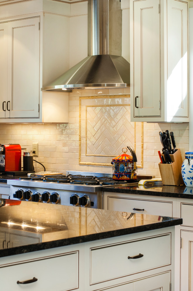 Inspiration for a transitional u-shaped medium tone wood floor kitchen remodel in New York with a farmhouse sink, beaded inset cabinets, white cabinets, granite countertops, beige backsplash, subway tile backsplash, stainless steel appliances and an island
