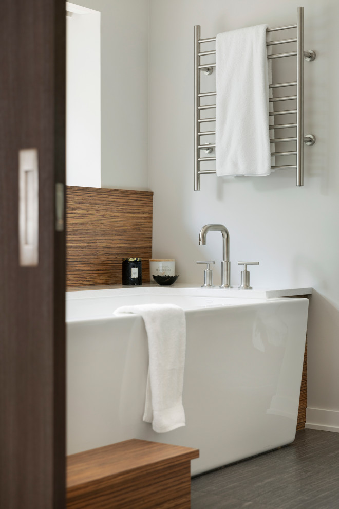 Inspiration pour une salle de bain principale design avec une baignoire indépendante, un mur blanc et un sol gris.