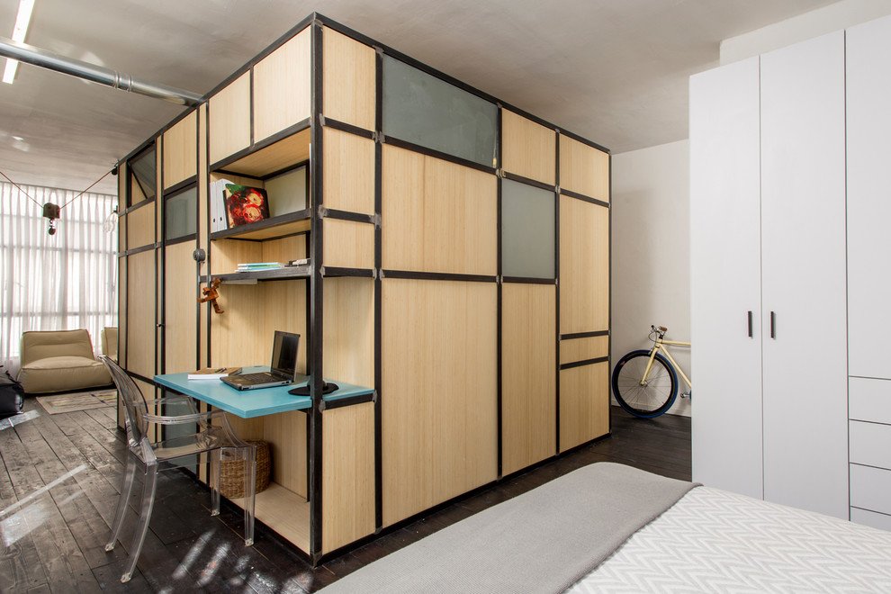 Photo of an industrial study room in Tel Aviv with white walls, dark hardwood floors and a built-in desk.