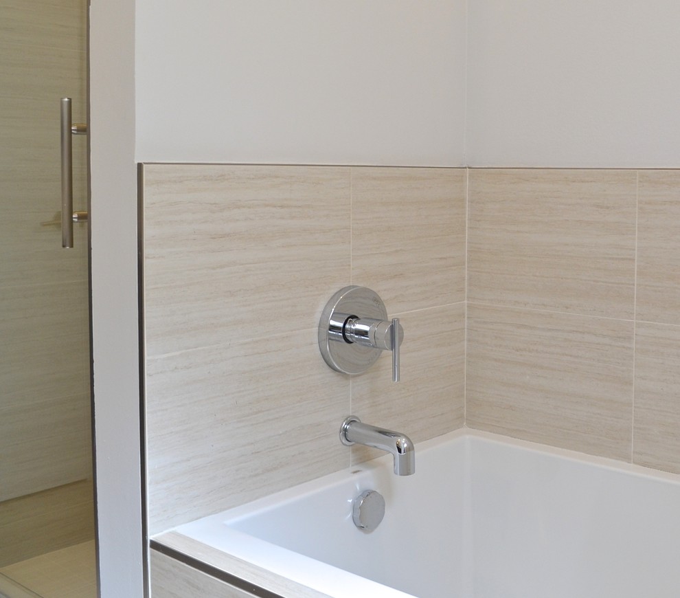 This is an example of a small modern master bathroom in Los Angeles with an undermount sink, flat-panel cabinets, brown cabinets, solid surface benchtops, a drop-in tub, an alcove shower, a one-piece toilet, beige tile, porcelain tile, white walls and porcelain floors.
