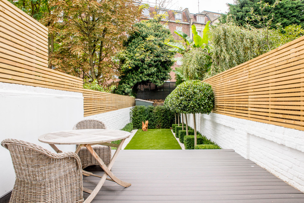 Inspiration for a small transitional backyard full sun formal garden in London with decking.