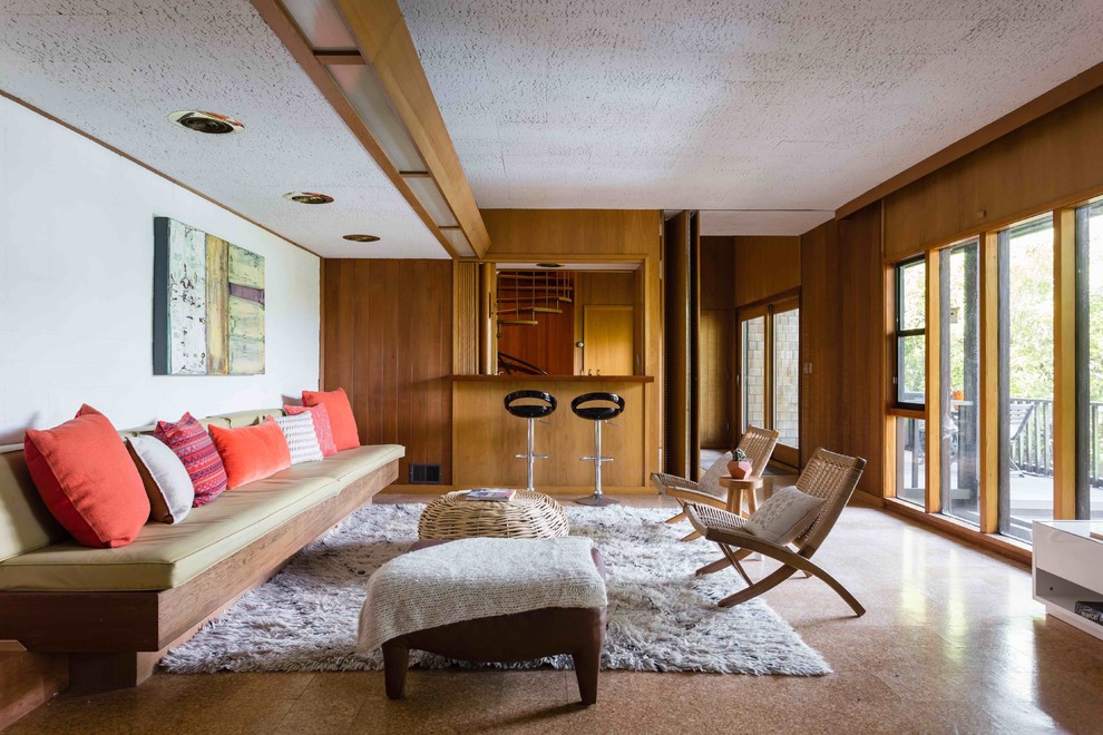 Large midcentury open concept family room in San Francisco with a home bar, cork floors, a standard fireplace and a concrete fireplace surround.