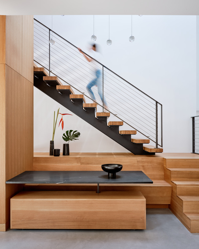 Foto de escalera en L minimalista de tamaño medio sin contrahuella con escalones de madera y barandilla de metal