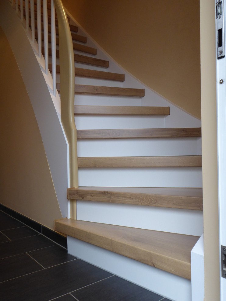 Modelo de escalera curva campestre grande con escalones de madera, contrahuellas con baldosas y/o azulejos y barandilla de varios materiales