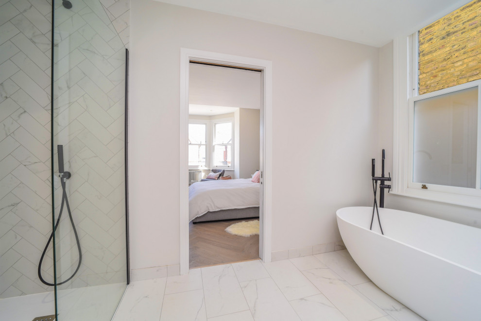 Mid-sized trendy master bathroom photo in London with flat-panel cabinets, white cabinets and a freestanding vanity