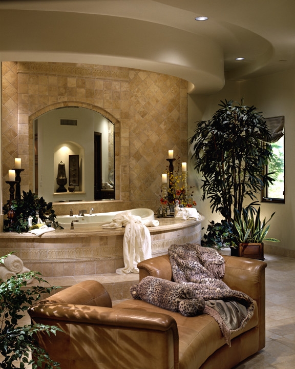 This is an example of an expansive mediterranean master bathroom in Phoenix with flat-panel cabinets, light wood cabinets, a hot tub, a double shower, a one-piece toilet, beige tile, stone tile, beige walls, travertine floors, an integrated sink and tile benchtops.