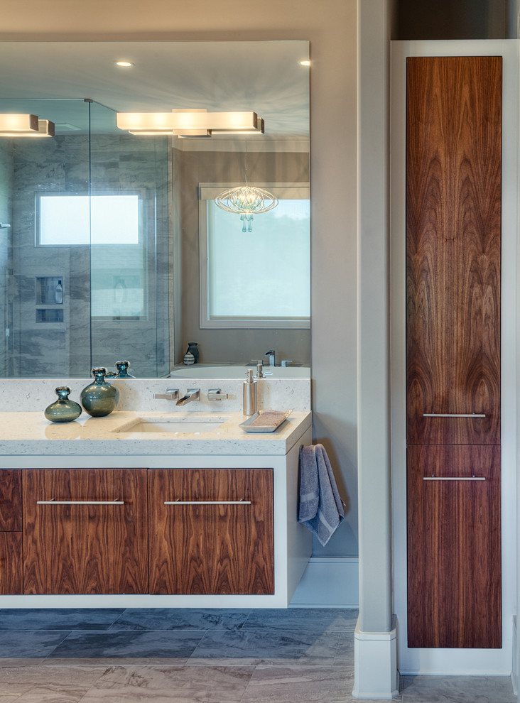 Large modern master bathroom in Other with flat-panel cabinets, medium wood cabinets, solid surface benchtops, a freestanding tub, gray tile, porcelain tile and porcelain floors.