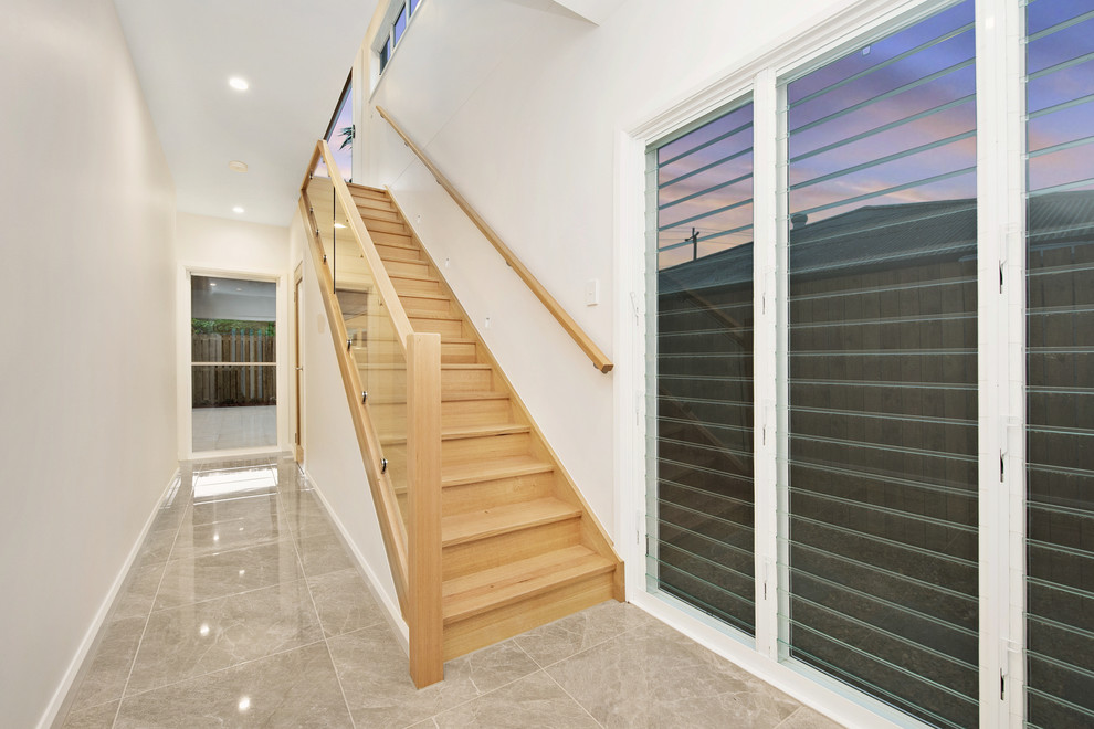 Contemporary wood straight staircase in Brisbane with glass railing.
