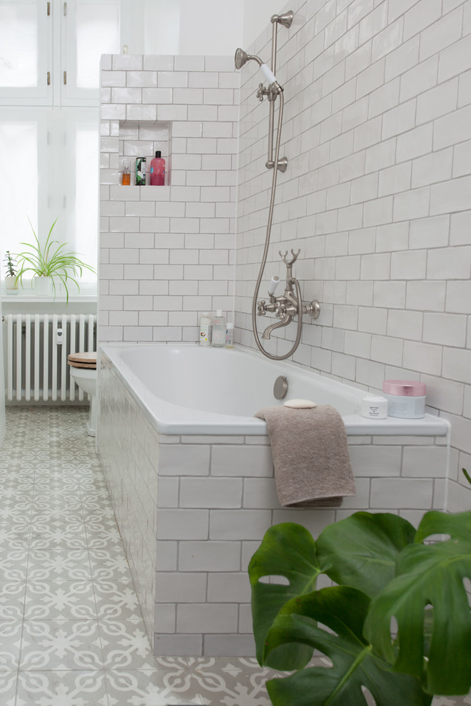 Duschbad mit Einbaubadewanne, Wandtoilette mit Spülkasten, weißen Fliesen, Keramikfliesen, weißer Wandfarbe, Zementfliesen für Boden und grauem Boden in Berlin