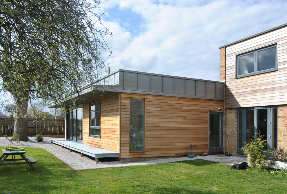 Design ideas for a small and multi-coloured modern bungalow detached house in Cambridgeshire with wood cladding, a flat roof and a metal roof.