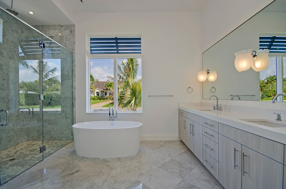 Inspiration for a contemporary bathroom in Miami with an undermount sink, flat-panel cabinets, grey cabinets, a freestanding tub, an alcove shower, gray tile and white benchtops.