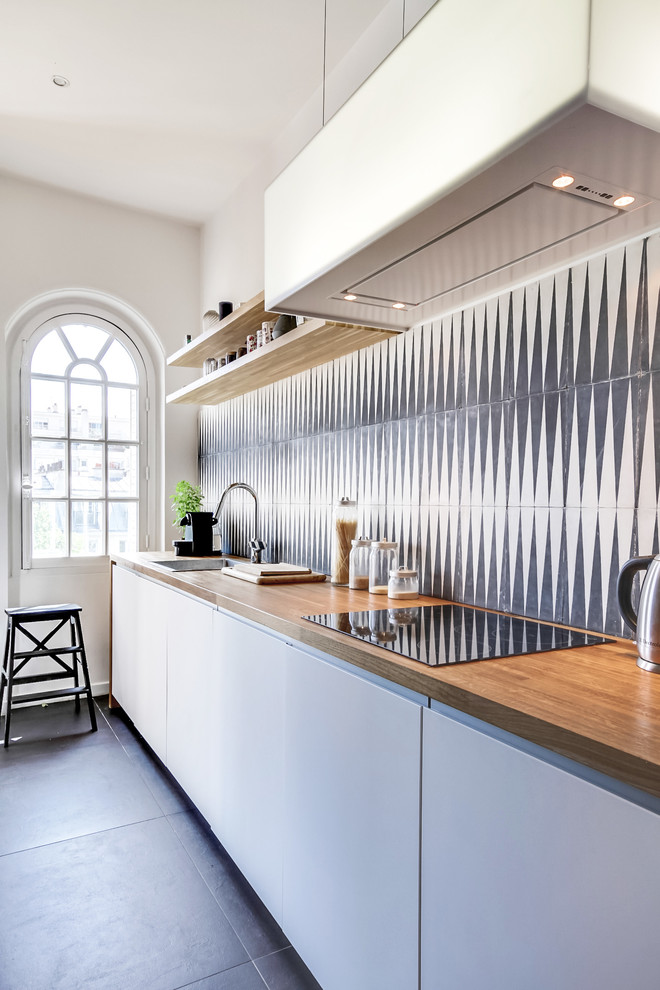 Mid-sized contemporary single-wall separate kitchen in Paris with flat-panel cabinets, white cabinets, wood benchtops, multi-coloured splashback and no island.