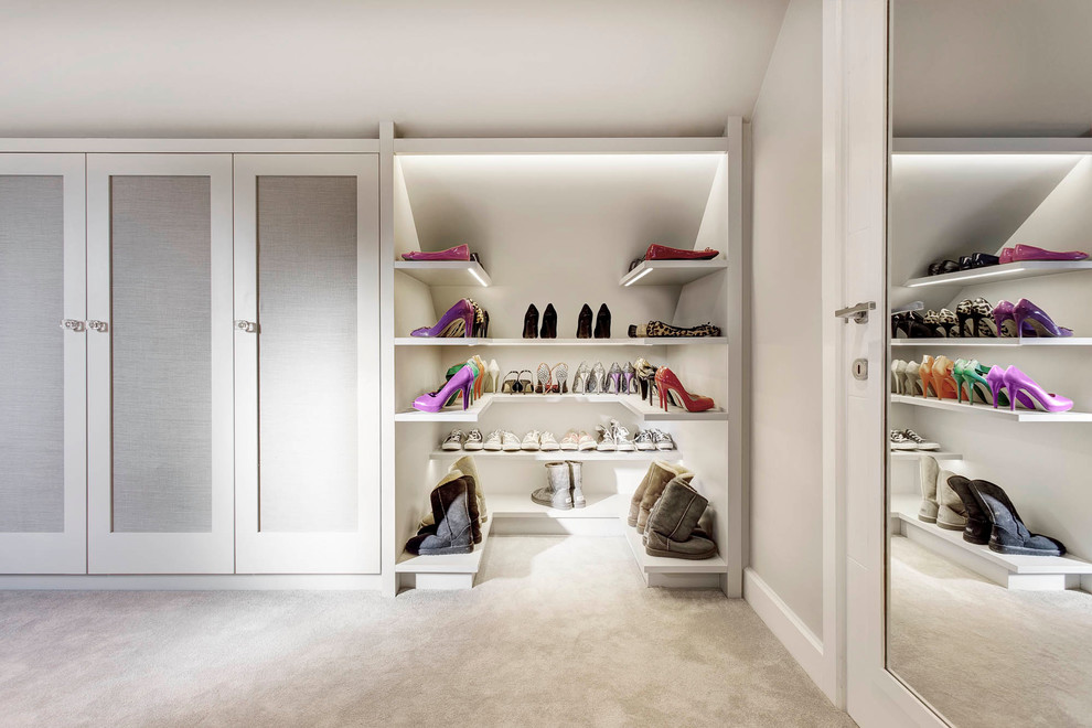 Inspiration for a large contemporary women's dressing room in London with shaker cabinets, white cabinets and carpet.