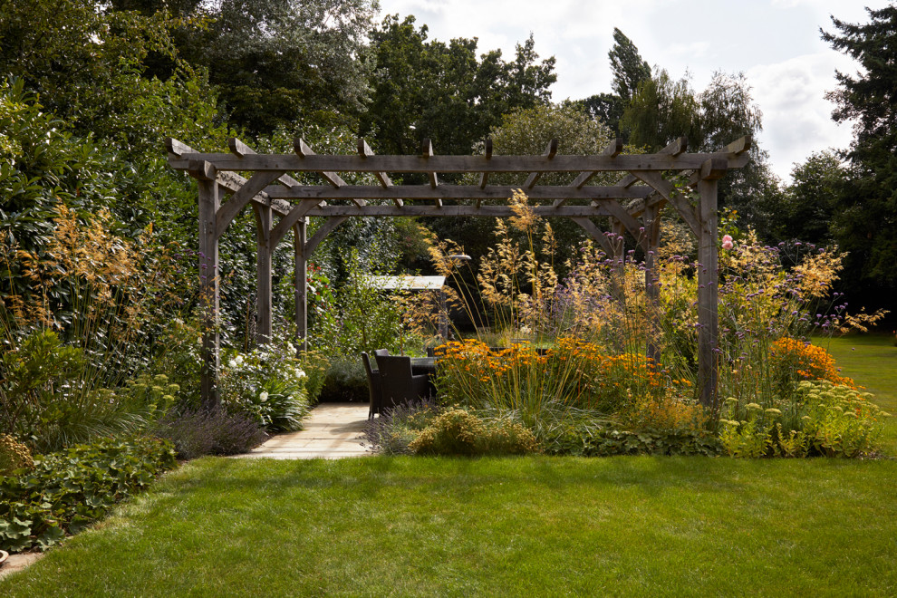 Photo of a traditional patio in Surrey with a pergola.