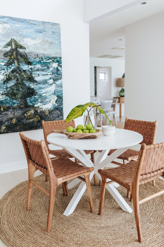 Photo of a beach style dining room in Wollongong with white walls, light hardwood floors and beige floor.