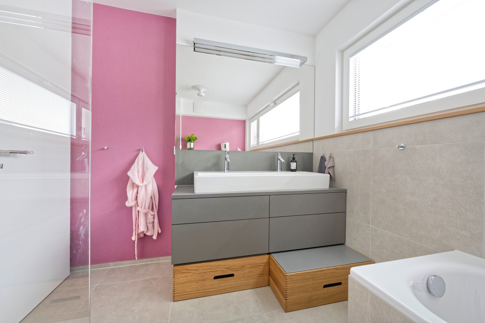 Mittelgroßes Modernes Kinderbad mit flächenbündigen Schrankfronten, grauen Schränken, Einbaubadewanne, Eckdusche, grauen Fliesen, Porzellanfliesen, weißer Wandfarbe, Porzellan-Bodenfliesen, Trogwaschbecken, grauem Boden und grauer Waschtischplatte in München